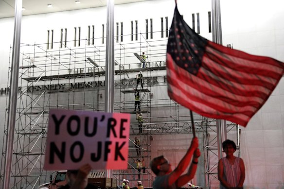People wait for President Donald Trump’s name to be removed from the centre.