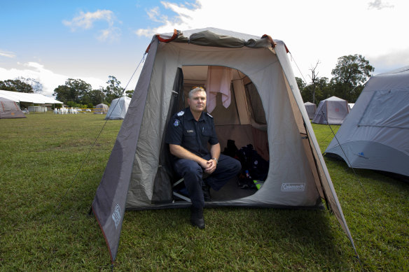 Victoria Police Acting Senior Sergeant Colin Shepherd who was deployed from the Bass Coast sits in his tent at Cann River on Wednesday.
