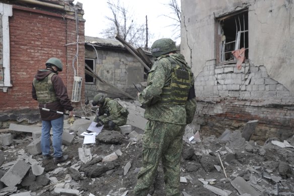 Investigators inspect a site of an apartment building after shelling by Ukrainian forces in Makiivka, Donetsk People’s Republic, eastern Ukraine, last week.