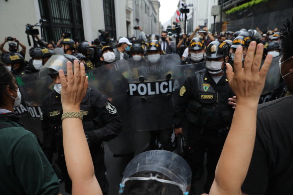 Police block supporters of former President Martin Vizcarra protesting near Congress while lawmakers swear-in Manuel Merino, head of Peru's legislature, as the new president in Lima on Tuesday.