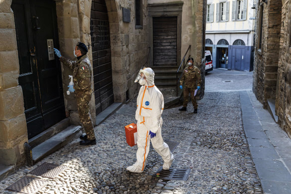 A Red Cross worker visits to the home of a COVID-19 patient in Bergamo, Italy.