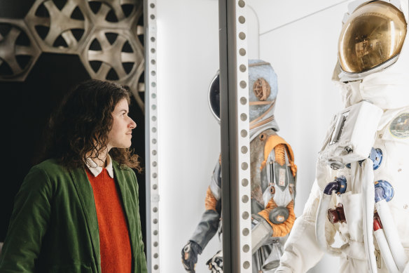 A room labelled Cosmic Curiosities has a selection of spacesuits used onscreen on display.