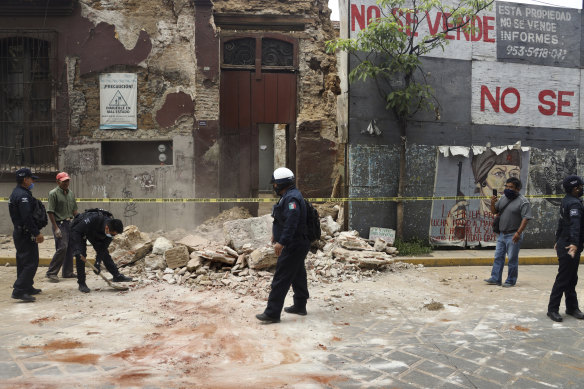 A policeman removes rubble from a building damaged by an earthquake in Oaxaca.