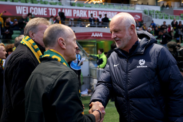 Head coach Graham Arnold greets past Socceroos players.