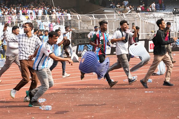 Disgruntled fans vandalise stadium chairs as they run on to the field after failing to get a glimpse of Argentine soccer star Lionel Messi.