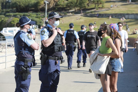 Police check the address of people at Bondi Beach during a lockdown last year.