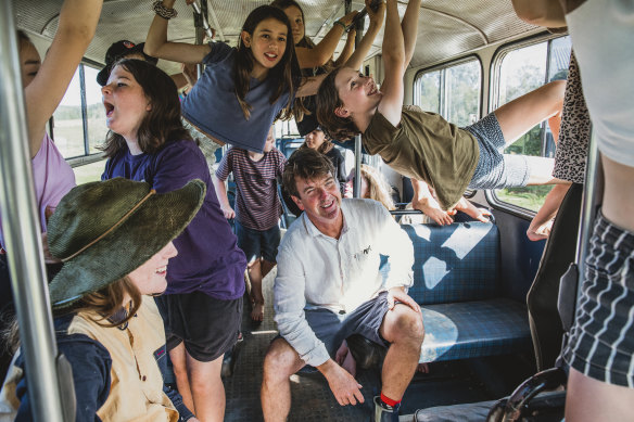 Living School principal John Stewart and students on a school bus used as a learning room.