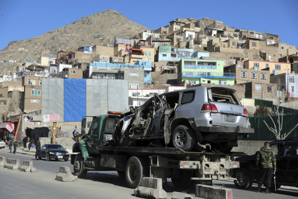 A damaged vehicle in a sticky bomb attack that killed a policeman is removed from the site in Kabul, Afghanistan, on Saturday. 