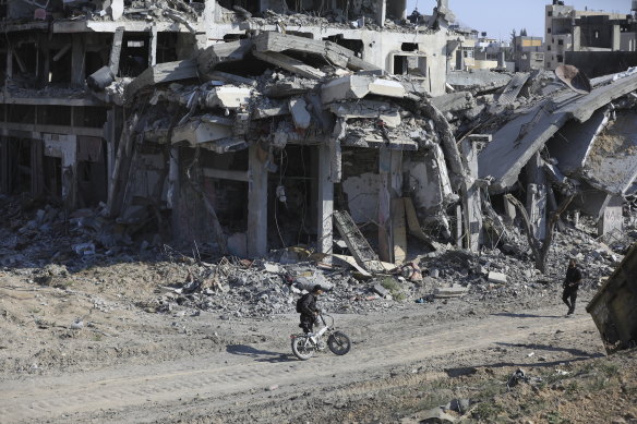 Palestinians walk through the destruction left by the Israeli air and ground offensive after the IDF withdrew from Khan Younis on Sunday.