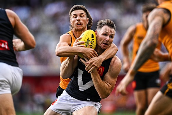 Patrick Dangerfield wears a tackle from WA’s Liam Baker.