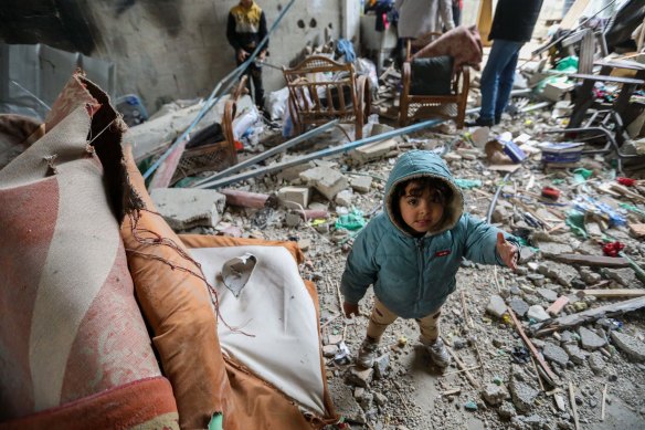 A child is pictured among the rubble of a house in Rafah, Gaza.