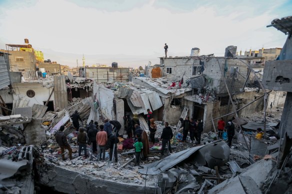 People inspect the damage to their homes following Israeli air strikes in Rafah.