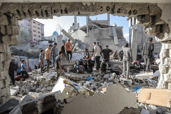 People search buildings destroyed by Israeli airstrikes in Khan Yunis, southern Gaza, on November 18.