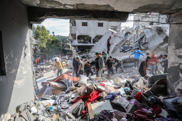 Palestinian citizens carry out search and rescue operations amid the destruction caused by Israeli air strikes in Khan Younis, Gaza.