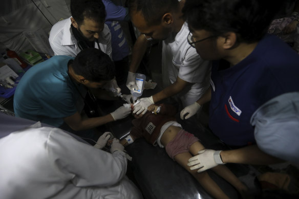 Palestinian medics treat a wounded child in Rafah, Gaza Strip on Saturday.