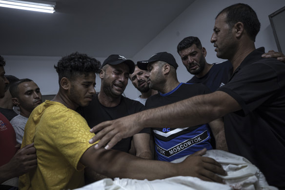 Relatives of Palestinian Noor Al Zubaidi, who was killed during an Israeli air strike in Beit Hanoun, react during his funeral at Al-Shifa hospital in Gaza City.