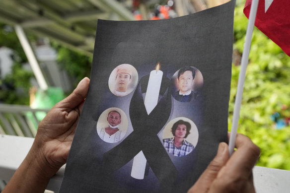 A Myanmar national living in Thailand holds the pictures of the executed political prisoners in Myanmar, as they protest outside Myanmar’s embassy in Bangkok last month.