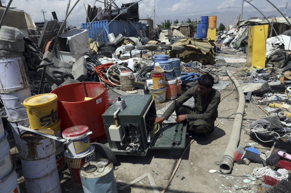 A scrap dealer checks equipment in a scrapyard outside Bagram Air Base, which was  emptied of US troops on Friday after 20 years. 