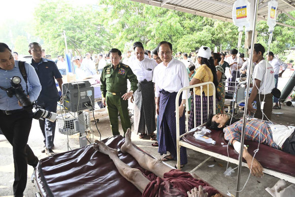 Myanmar’s military leader Senior General Min Aung Hlaing, centre, visits earthquake victims in hospital. in Naypyitaw.