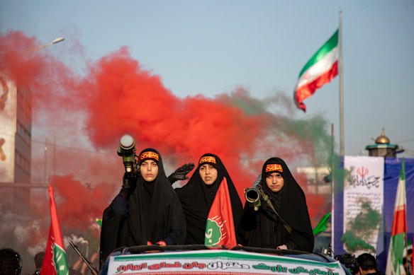 Women carrying weapons resembling shoulder-fired missiles ride in a truck during a pro-government National Army Day demonstration on April 17 in Tehran, Iran. 