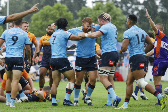 Harry Johnson-Holmes and Waratahs players celebrate after a try in a trial win over the Brumbies.