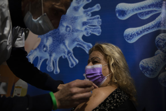 A woman receives a coronavirus vaccine from medical staff at a COVID-19 vaccination centre in Ramat Gan, Israel.