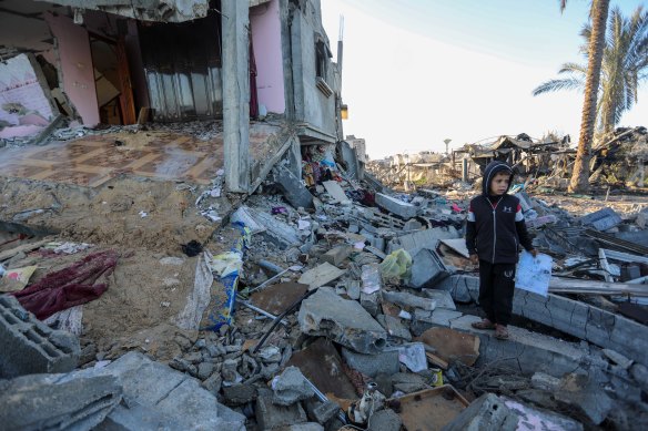 A young Palestinian inspects a destroyed building in Rafah, Gaza on Friday.