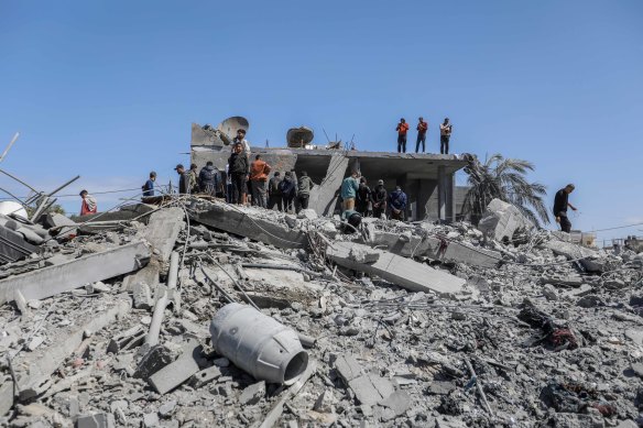 People inspect damage and recover items from their homes following Israeli airstrikes in Rafah, Gaza, on Wedneday.