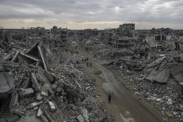 People walk amidst the destruction in Rafah, in the southern Gaza Strip.