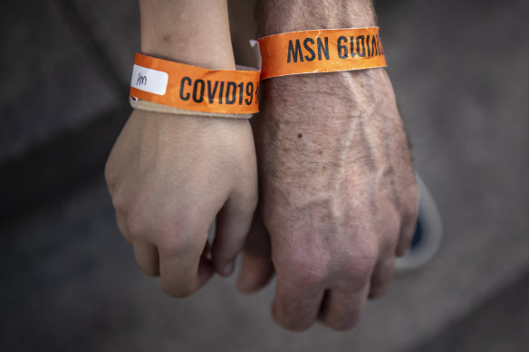 Andrew Thomas and his 10yo daughter Tamasin showcase quarantine braclets. 