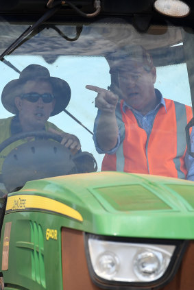 Mr Nicholls (right) joins Mr Greensill on his tractor during a tour of his farm.