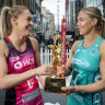 Adelaide Thunderbirds captain Hannah Petty and Melbourne Vixens counterpart Kate Moloney with the Super Netball trophy.