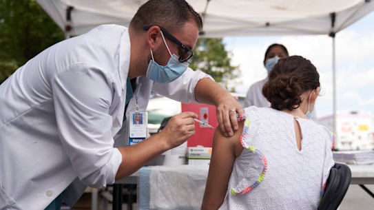 A healthcare worker administers a dose of the Pfizer vaccine to a student during a vaccination event at a school in Boston, Massachusetts.