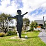 A sculpture at Bayswater train station of a little boy doing an aeroplane stance.
