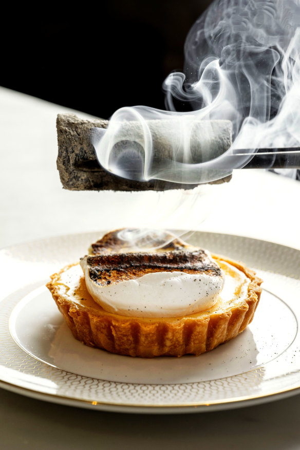 Custard and bergamot meringue tart, finished with charcoal at the table.