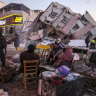 People stand by collapsed buildings in Golbasi, in Adiyaman province, southern Turkey.