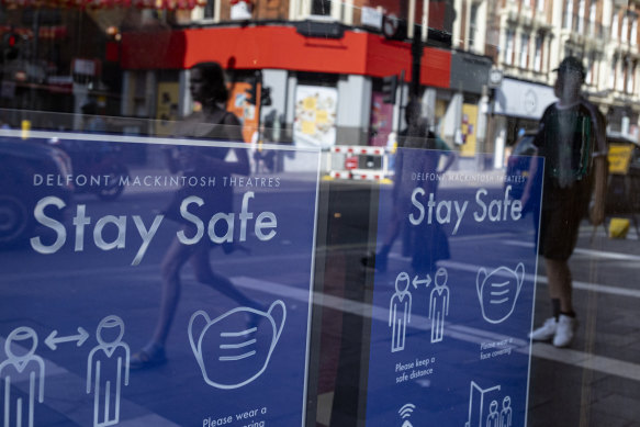 Coronavirus safety posters are displayed in the window of the Sondheim Theatre, London. England has maintained restrictions as a result of the Delta variant.