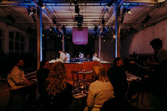 The Greek restaurant setting evokes the bustling world of hospo.