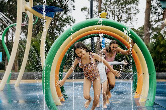 Uma família brincando no parque aquático do NRMA Ocean Beach Holiday Resort em Umina, Nova Gales do Sul.