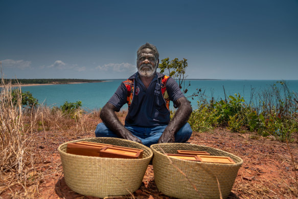 Ross Mandi Wunungmurra,  chair of the  Yalu Marnggithinyaraw Indigenous Corporation, in front of two baskets containing the blood.