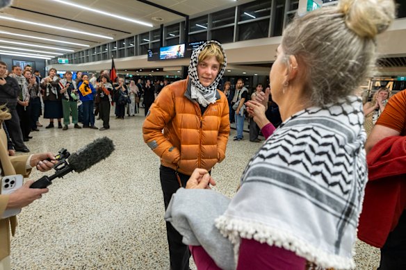 Gemma O'Toole fala à mídia na noite de domingo, depois de retornar à Austrália, enquanto seus apoiadores assistem.