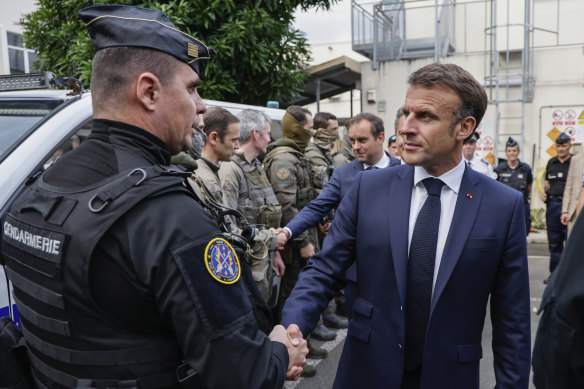 French President Emmanuel Macron visits the central police station in Noumea.