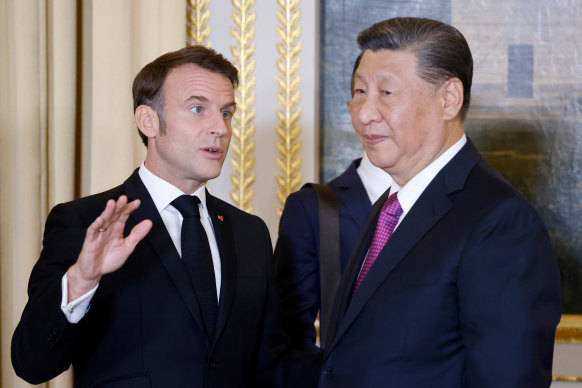 French President Emmanuel Macron talks with Chinese President Xi Jinping during a state dinner at the Elysee Palace in Paris on Monday.