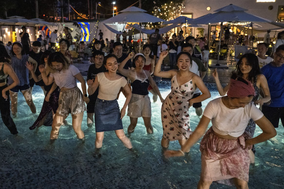 People dance in a swimming pool to cool off at a local restaurant during a heatwave on Sunday, July 2, in Beijing.