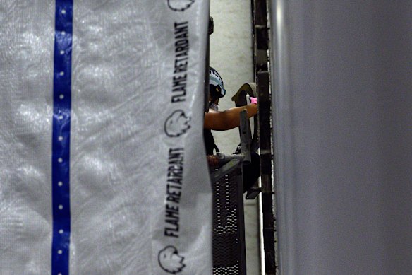A worker removes a letter from President Donald Trump’s name from the wall of the centre.