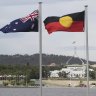 The Australian flag,  the Aboriginal flag and the Torres Strait Islander flag flying in Canberra.