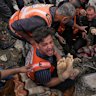 A dead man is removed from the rubble of the Manoun family’s house after it was targeted by an Israeli army strike in Jabalia al-Balad, Gaza City on Sunday.
