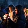 People hold candles during a vigil in Providence for the victims.