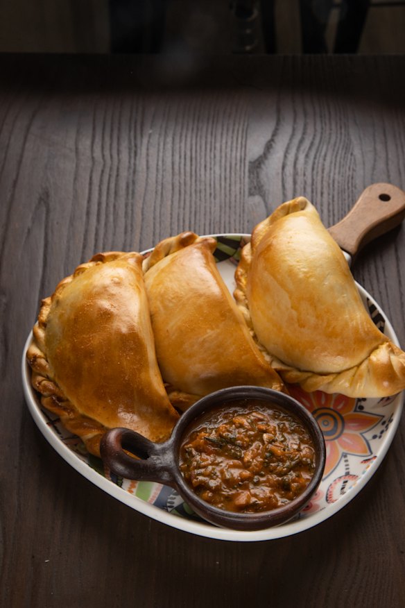The baked empanada de pino's minced beef filling includes a wedge of hard-boiled egg and a black olive.