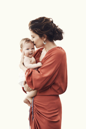 Higgins poses with baby Luna wearing a Bianca Spender “Madeline” dress and her own earrings.